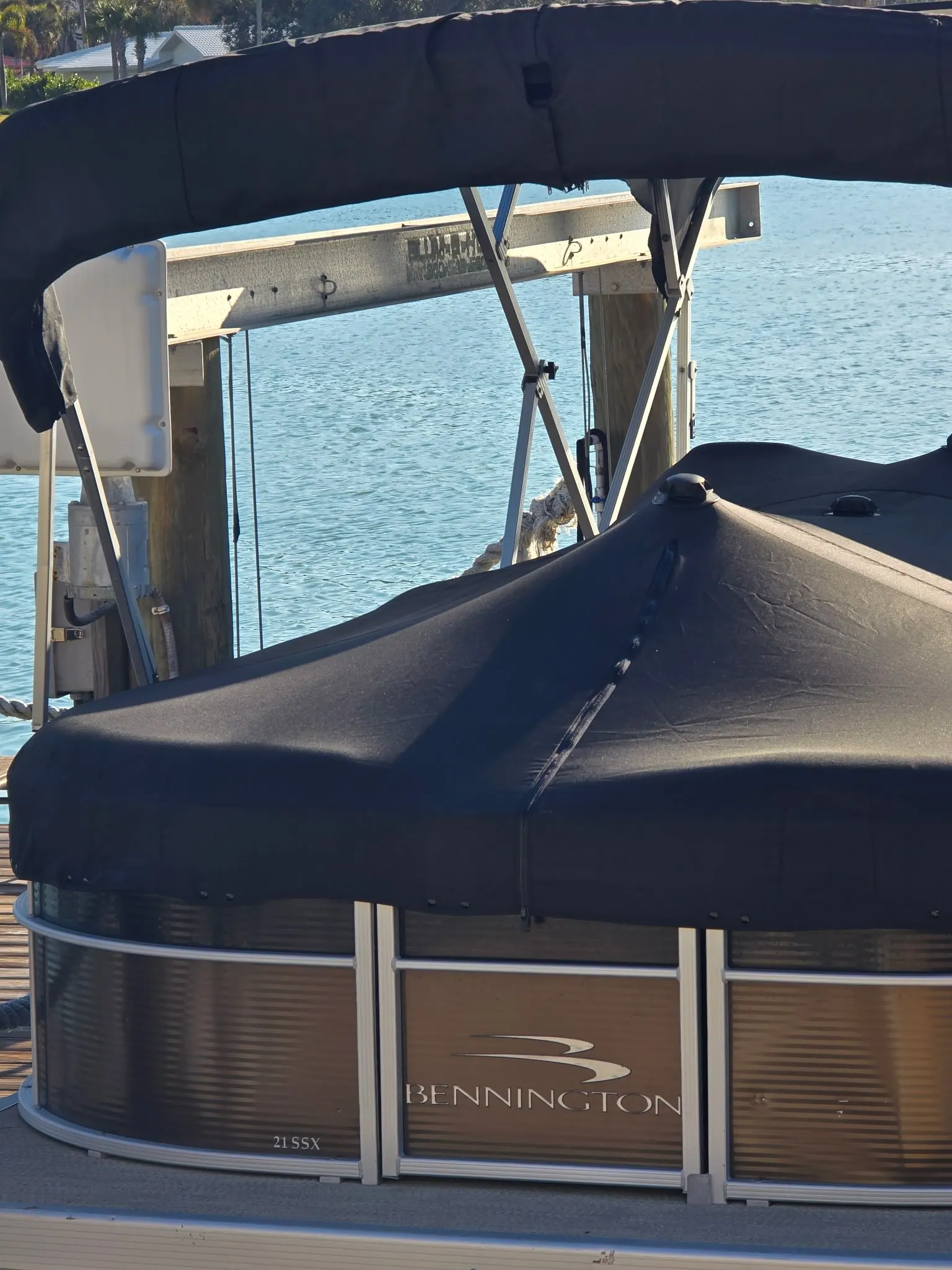 Custom black marine cover fitted on a Bennington pontoon boat at the dock in Venice, FL