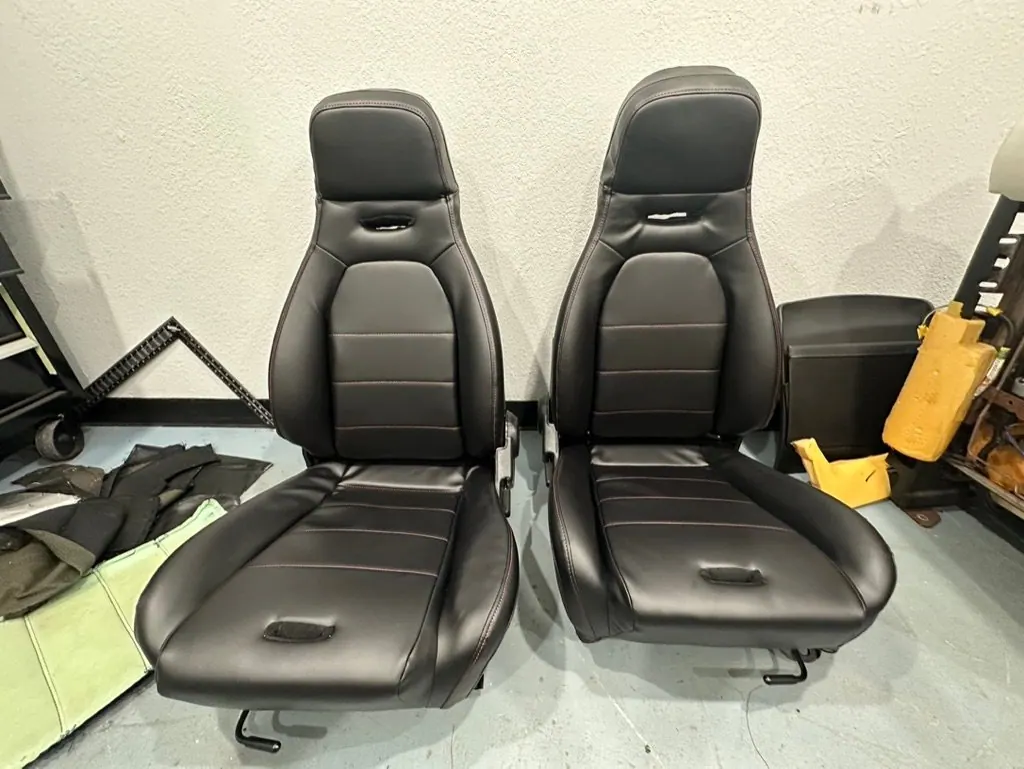 Pair of reupholstered black leather bucket seats in the shop