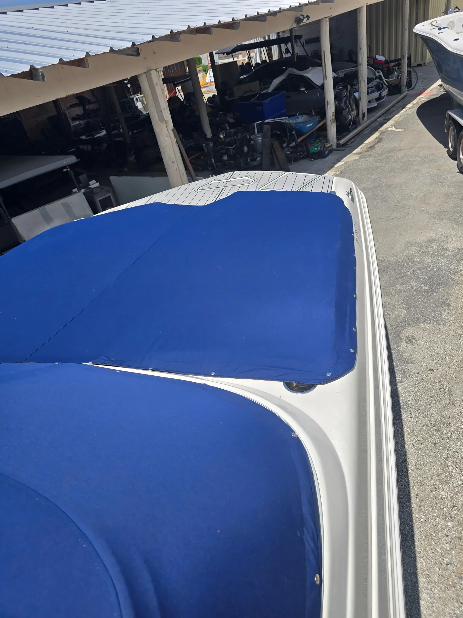Bow section of a royal blue custom boat cover fitted snug over the windshield