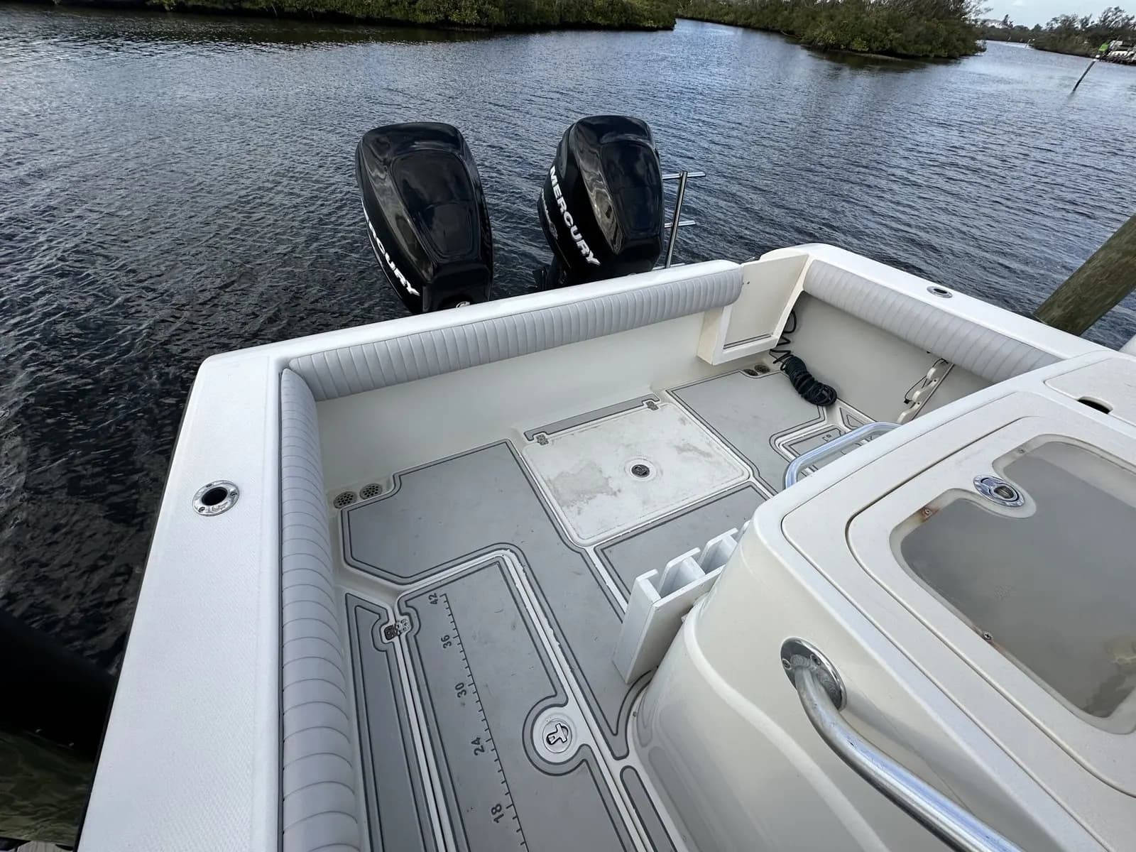 Center console cockpit with grey vinyl seating and twin outboards