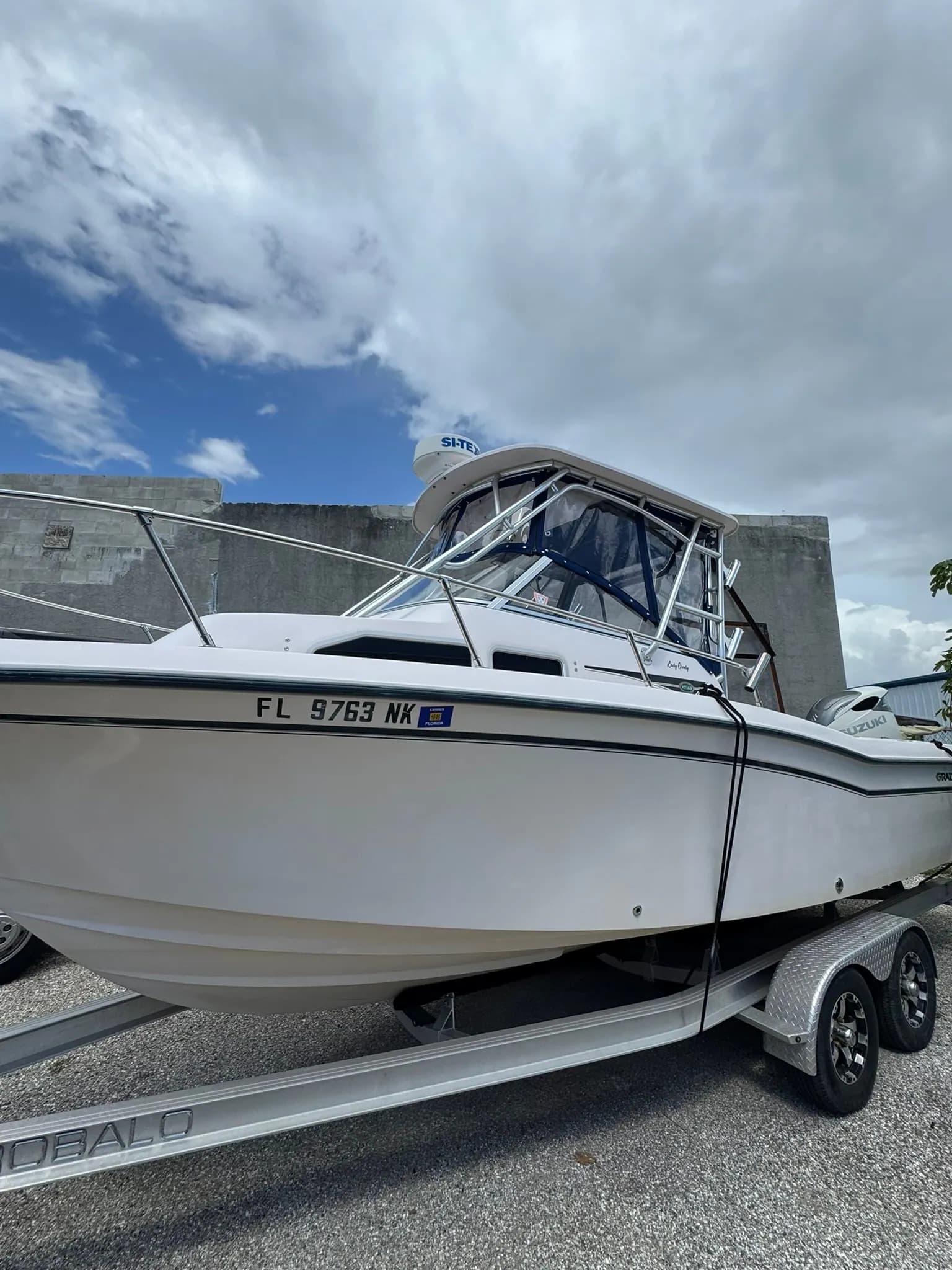 Center console fishing boat on its trailer after the T-top enclosure installation