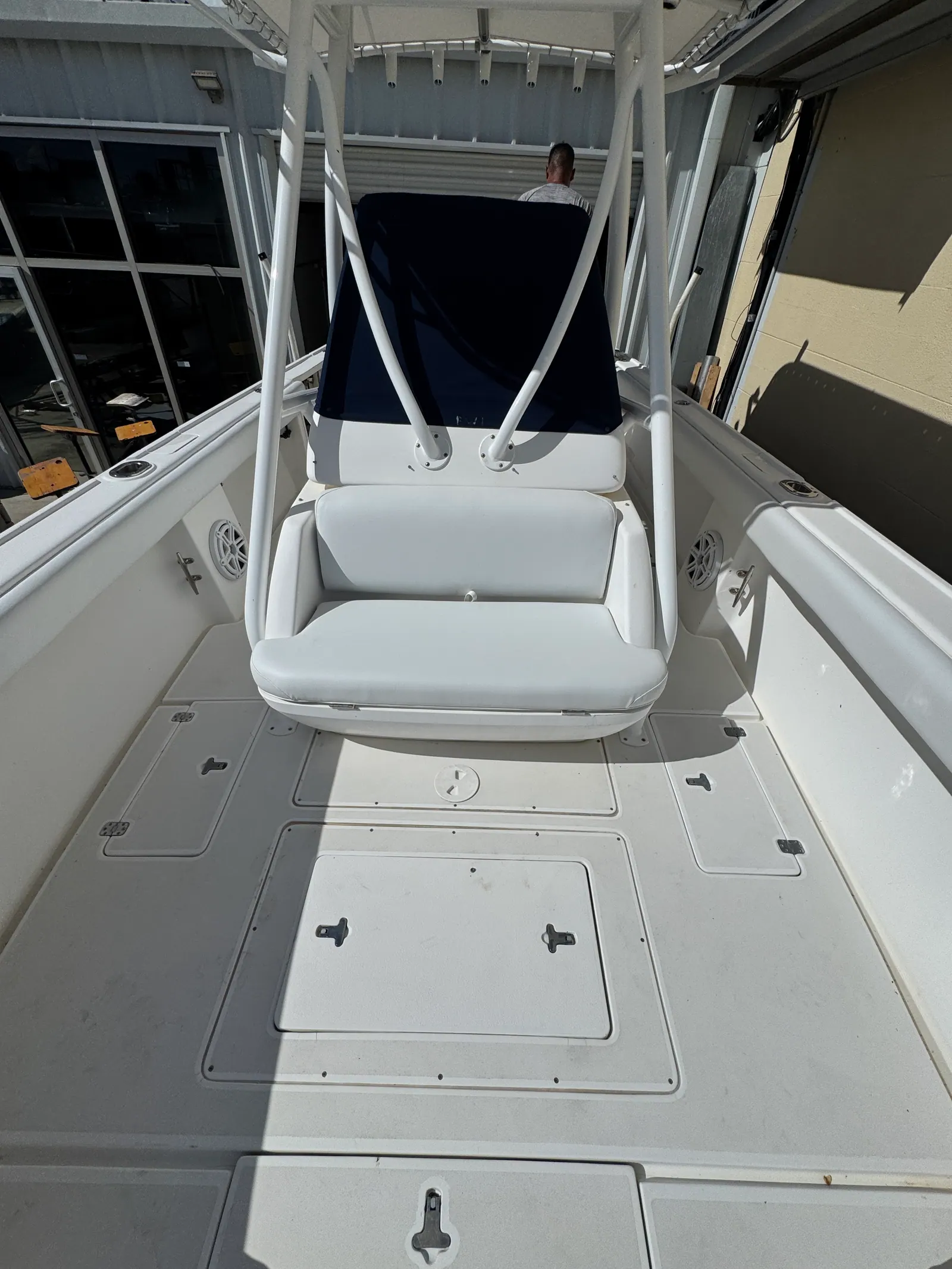 New white marine vinyl helm seat with flip-up bolster on a twin-Suzuki center console in our Venice, FL shop