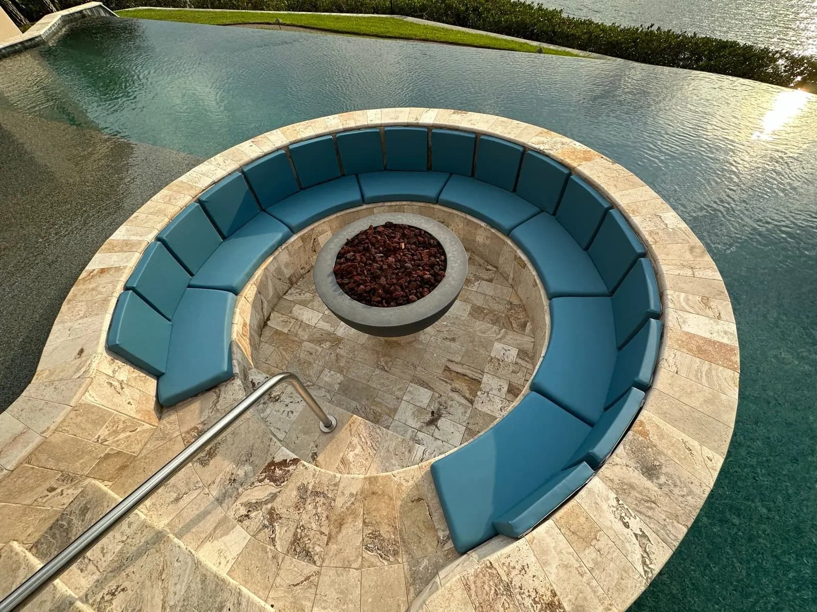 Flattened curved outdoor cushions around a poolside fire pit before we rebuilt them