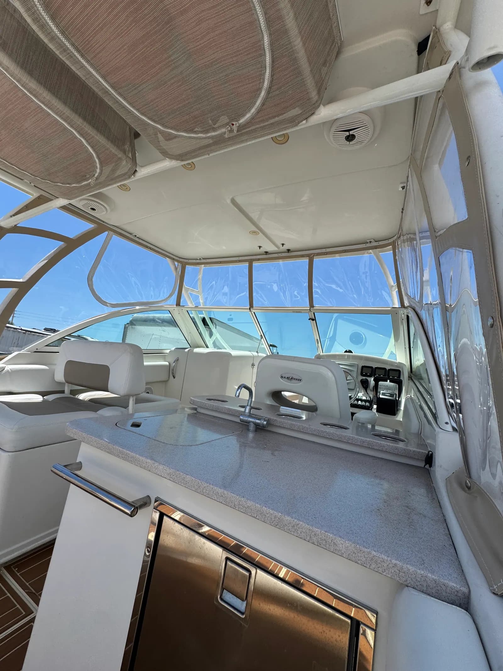 Helm of a center console seen through a clear vinyl hardtop enclosure built in Venice, FL