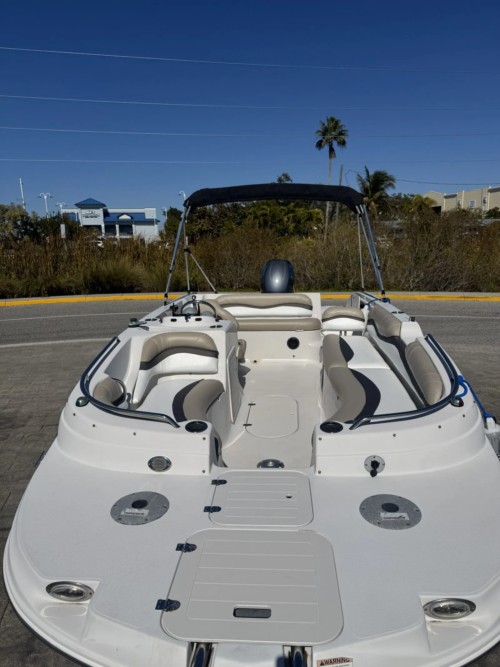 StarCraft 2000 deck boat with fully restored two-tone tan and white marine vinyl upholstery, bow view