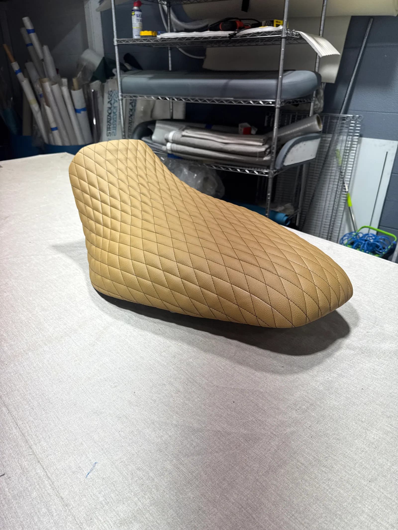 Side view of the tan diamond-stitched jet ski seat