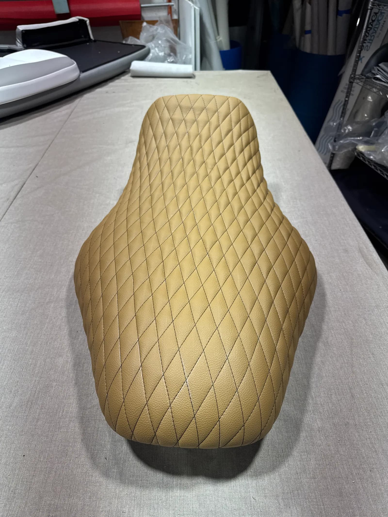 Tan diamond-stitched marine vinyl jet ski seat on the bench in our Venice, FL shop