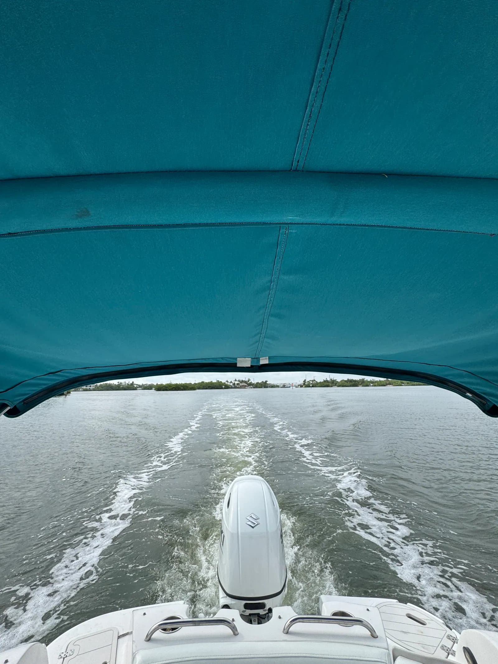 Teal bimini top shading the stern while cruising